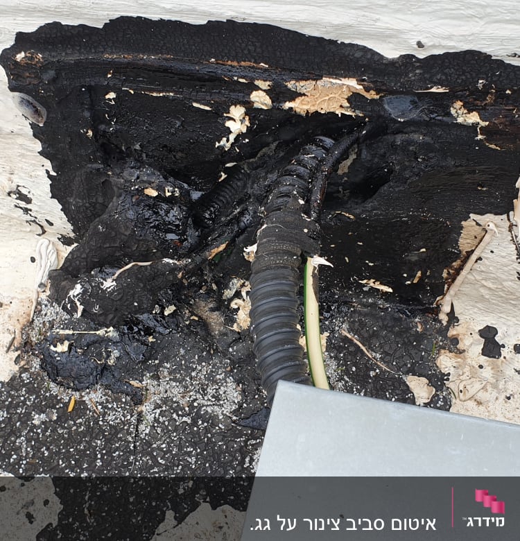 חומר איטום שחור סביב צינור בקיר חיצוני